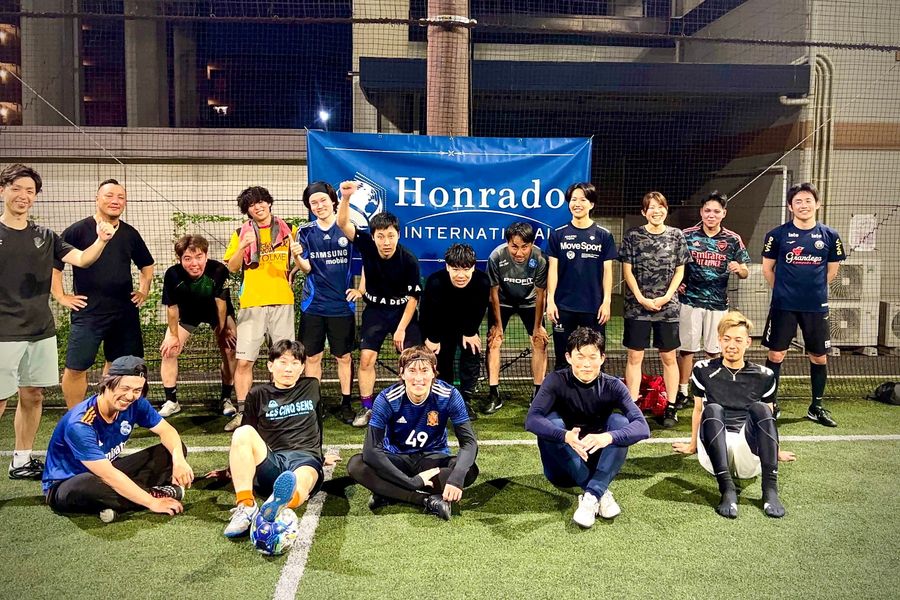 Honrado Internationalのバナーを囲んだ、フットサル定期開催の参加者の集合写真