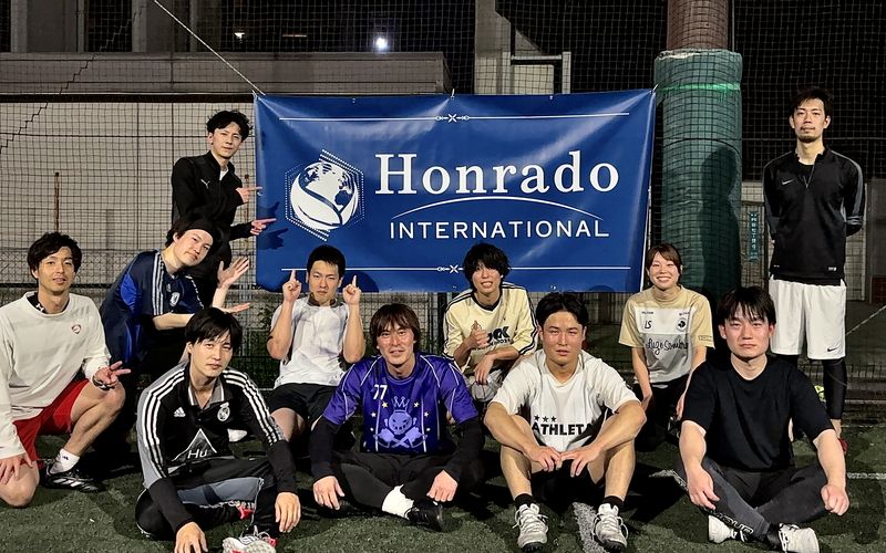 Honrado Internationalのバナーを囲んだ、フットサル参加者の集合写真