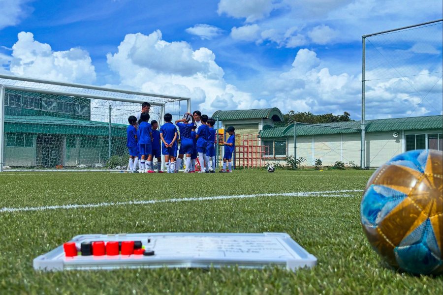 Japan Camp 2026の練習会場。芝生の上のボールと、奥でプレーする参加者